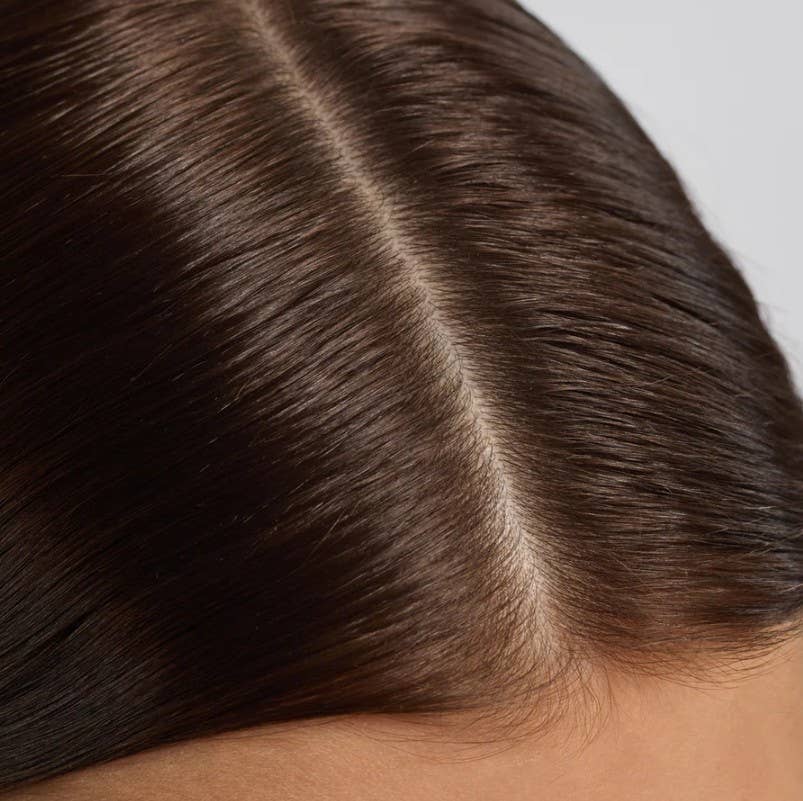 Close-up of a clean scalp part on dark brown hair