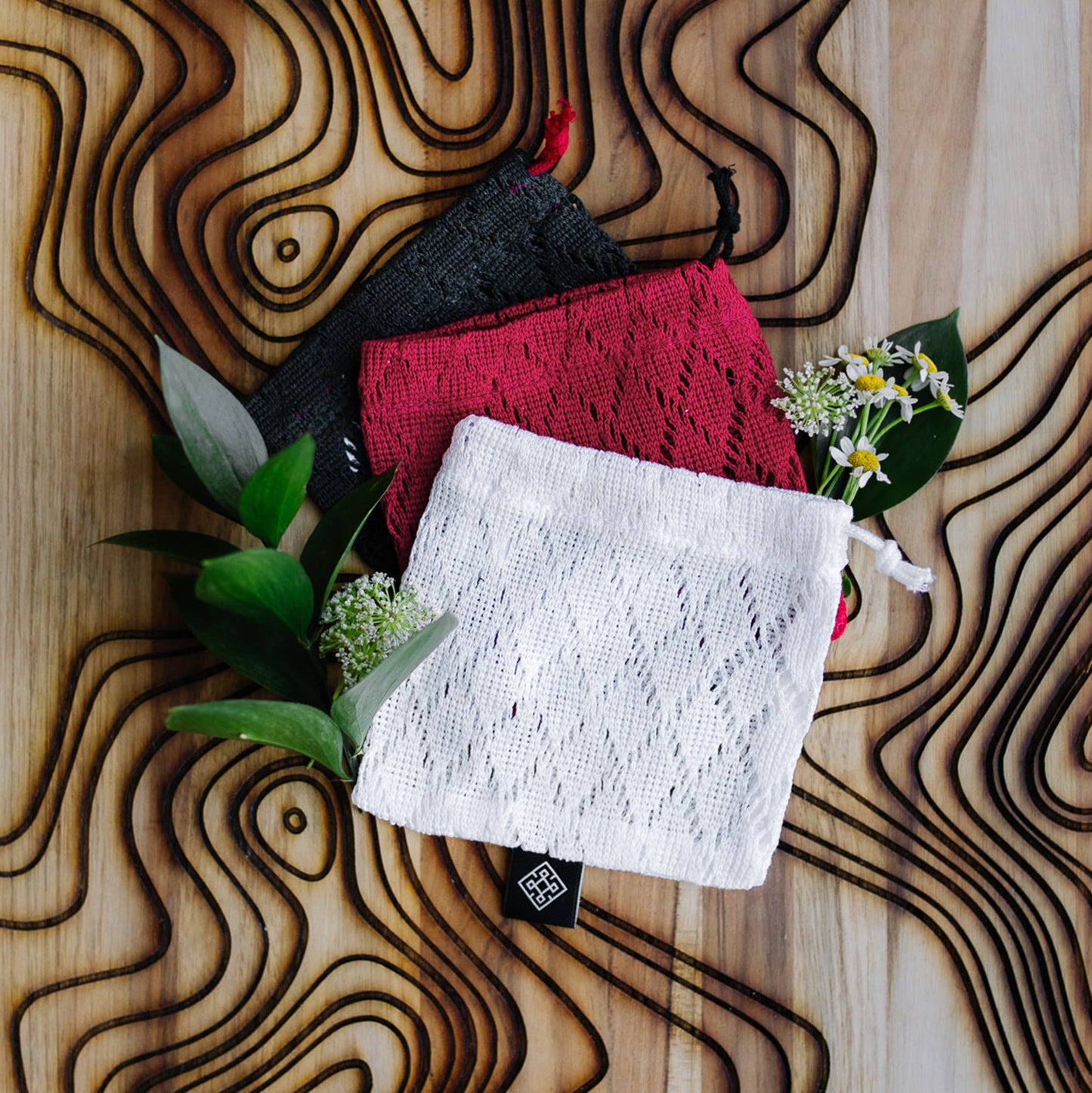 Red bamboo soap saver bag hanging to dry in the shower, salon-selected
