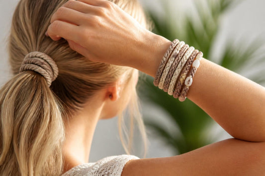 Stacked boho hair tie bracelets worn on a wrist and doubled around a smooth ponytail at The Pixie Garden