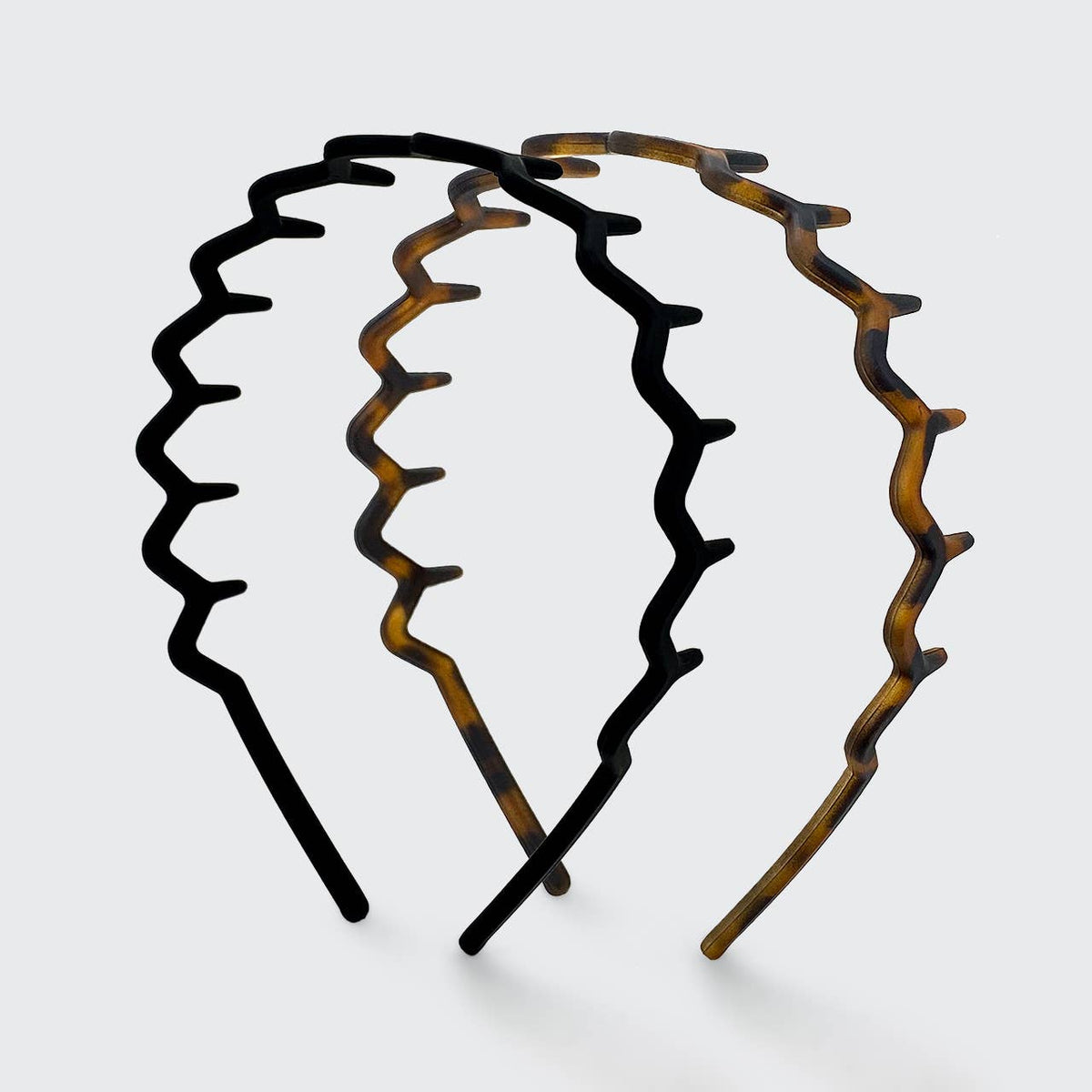 Black and tortoise zig zag headbands side by side showing the wavy comb teeth