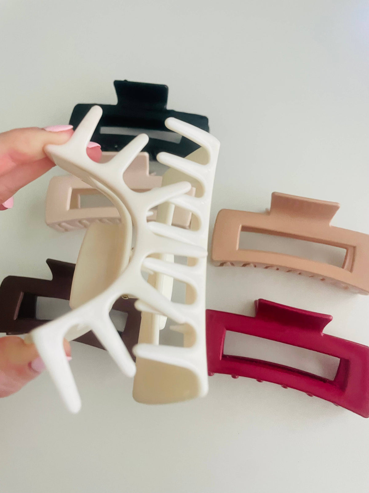 Hand bending a silicone rectangle claw clip to show the flexibility that keeps it from snapping