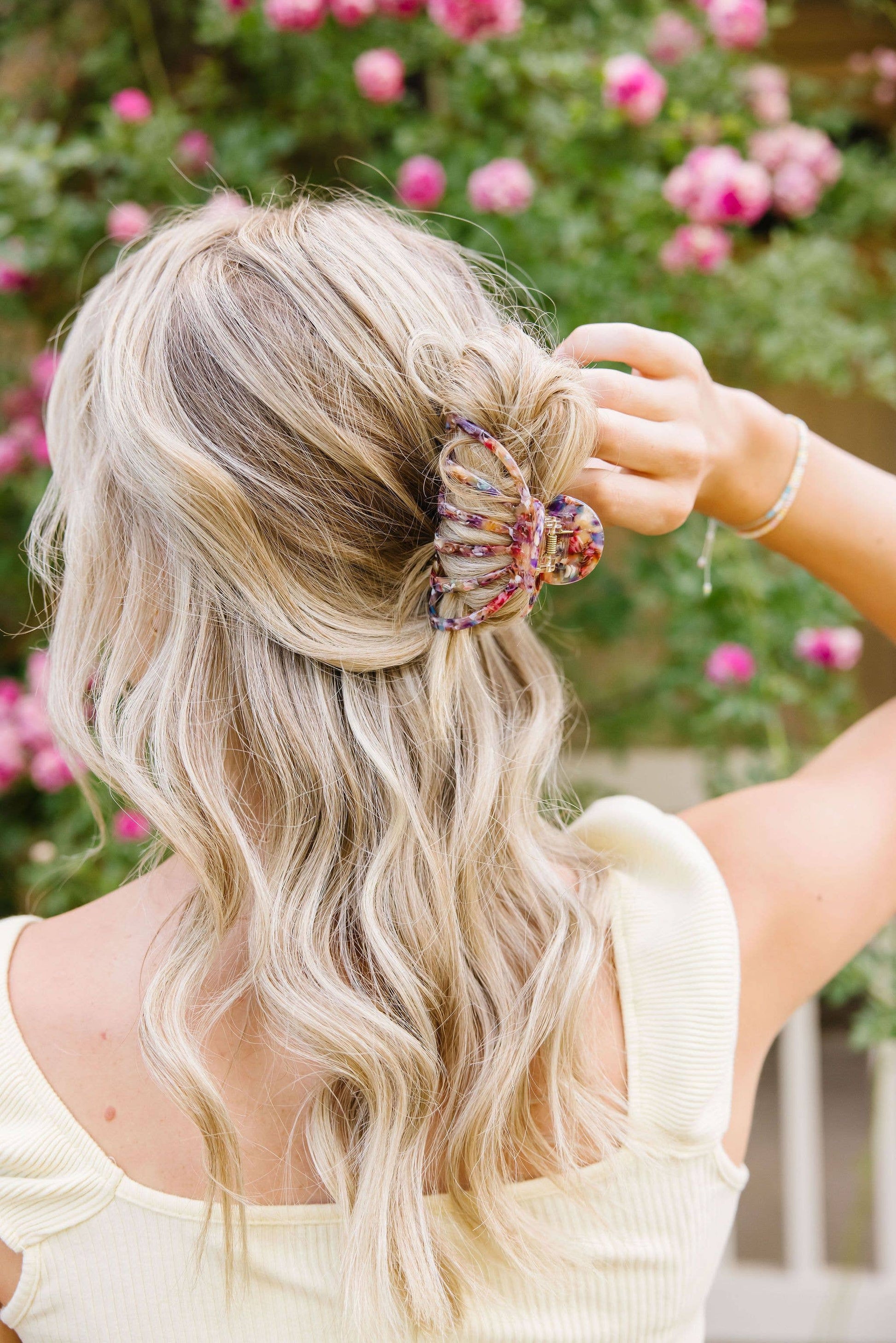 Carlisle claw clip worn in blonde updo floral background salon-selected The Pixie Garden