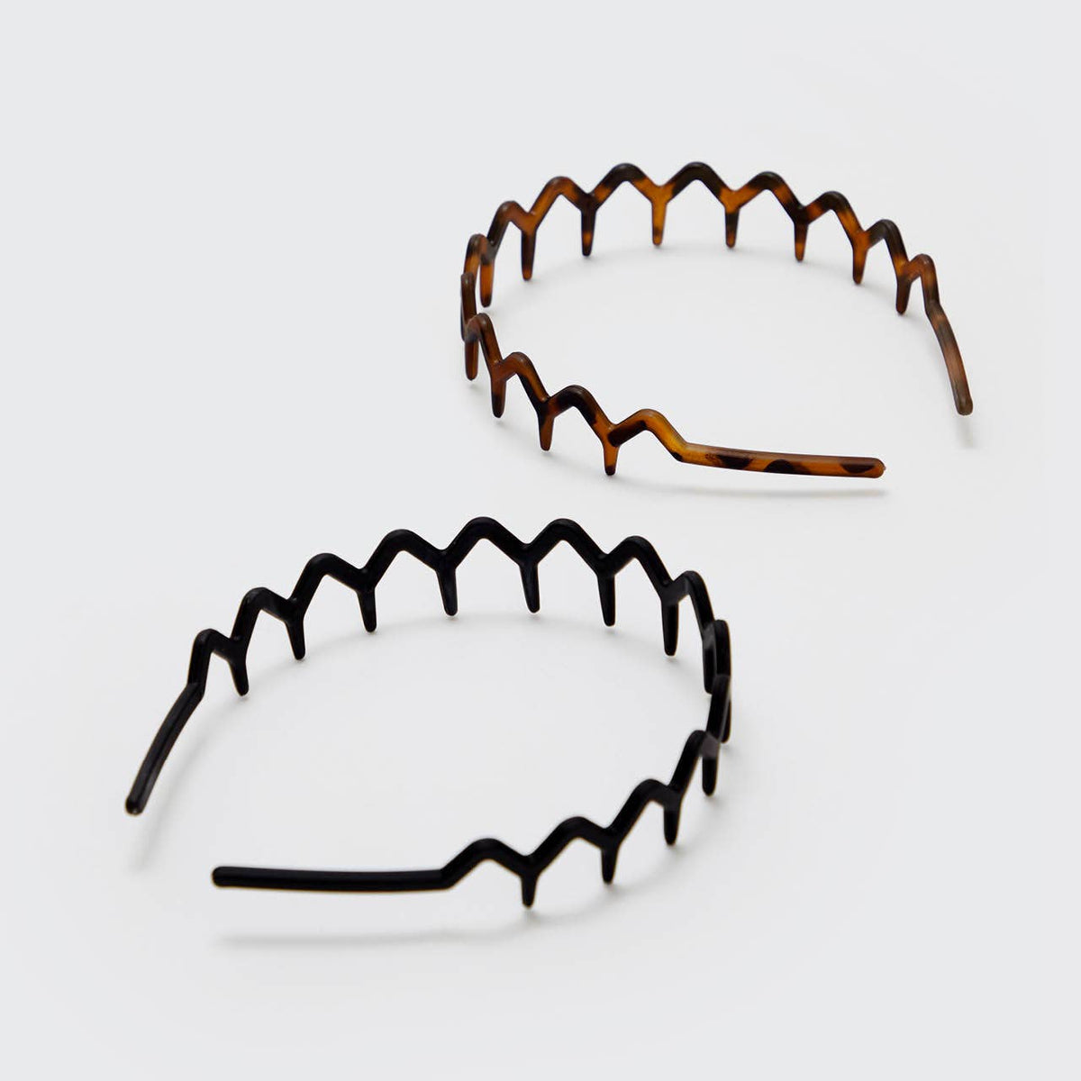 Black and tortoise zig zag headbands laid flat from above