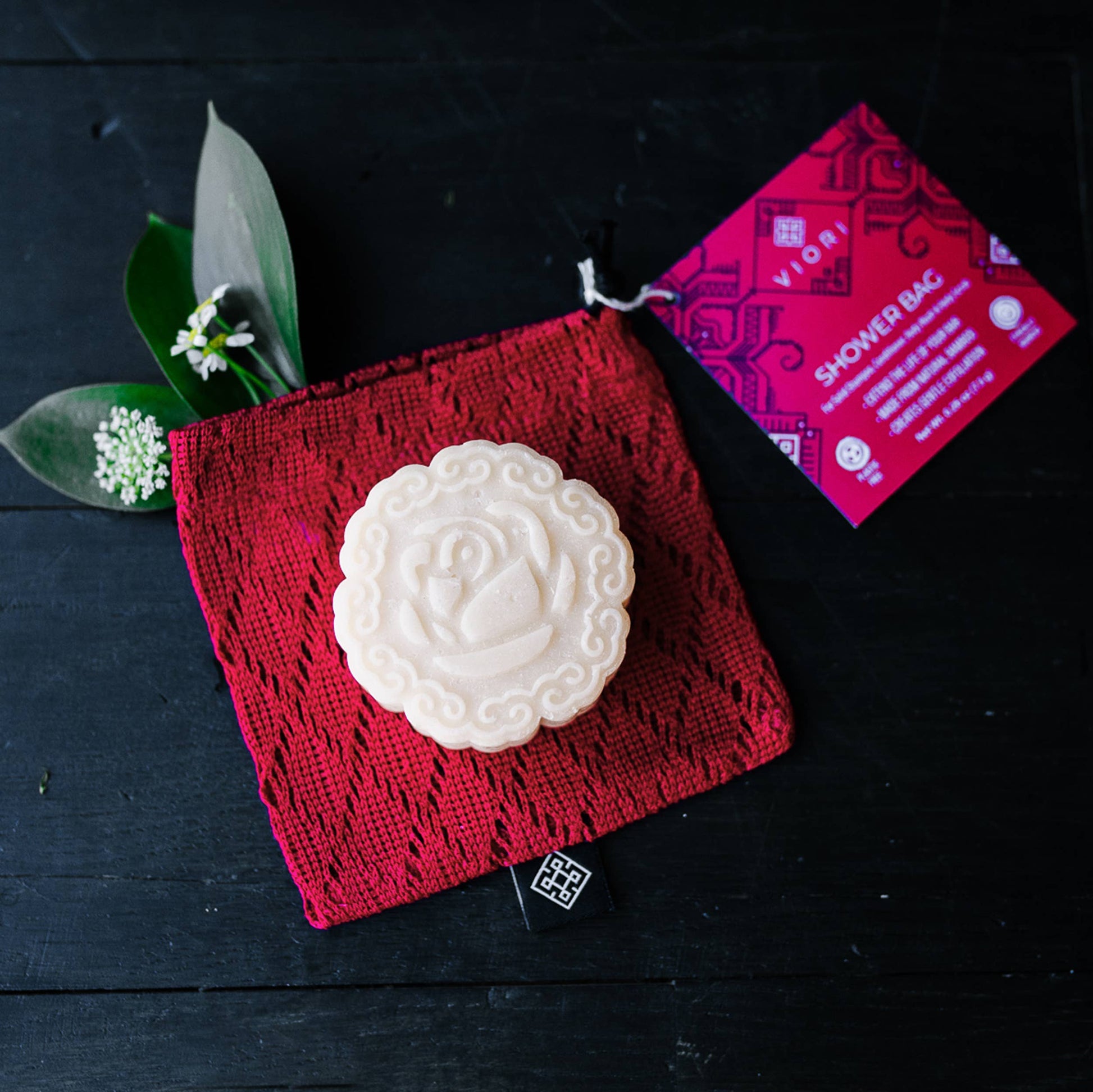 Breathable red bamboo soap bag holding a shampoo bar, plastic-free bath accessory, The Pixie Garden