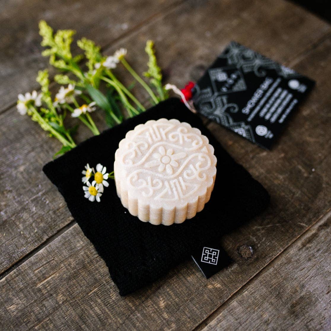 Breathable black bamboo soap bag holding a shampoo bar, plastic-free bath accessory, The Pixie Garden