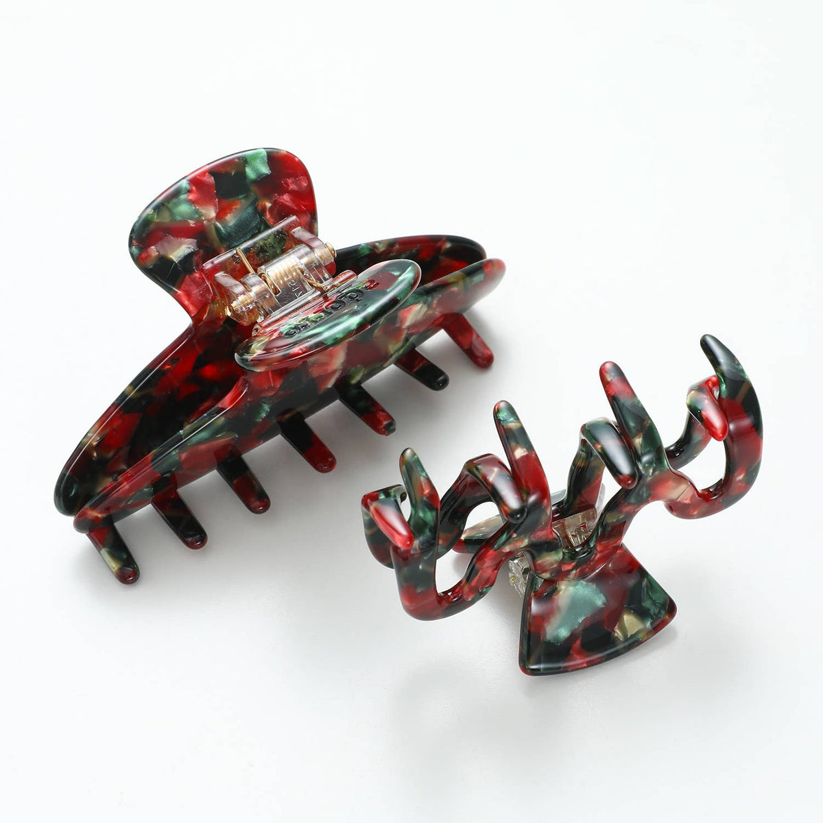 Curved Vintage Christmas claw clip opened to show its teeth, with a smaller clip behind it