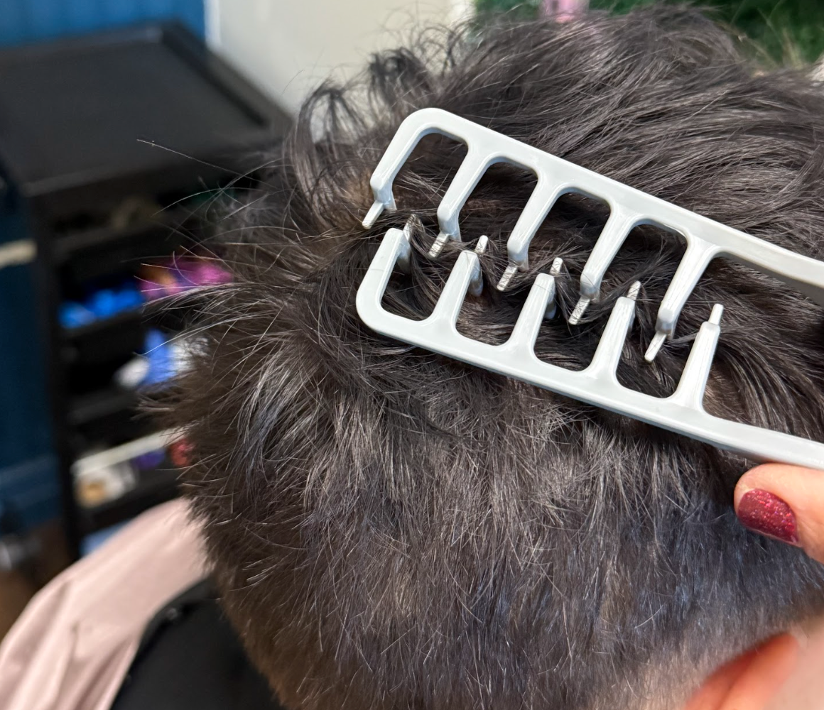Stylist using the Magic Texture Comb at the roots to add volume and texture to short dark hair