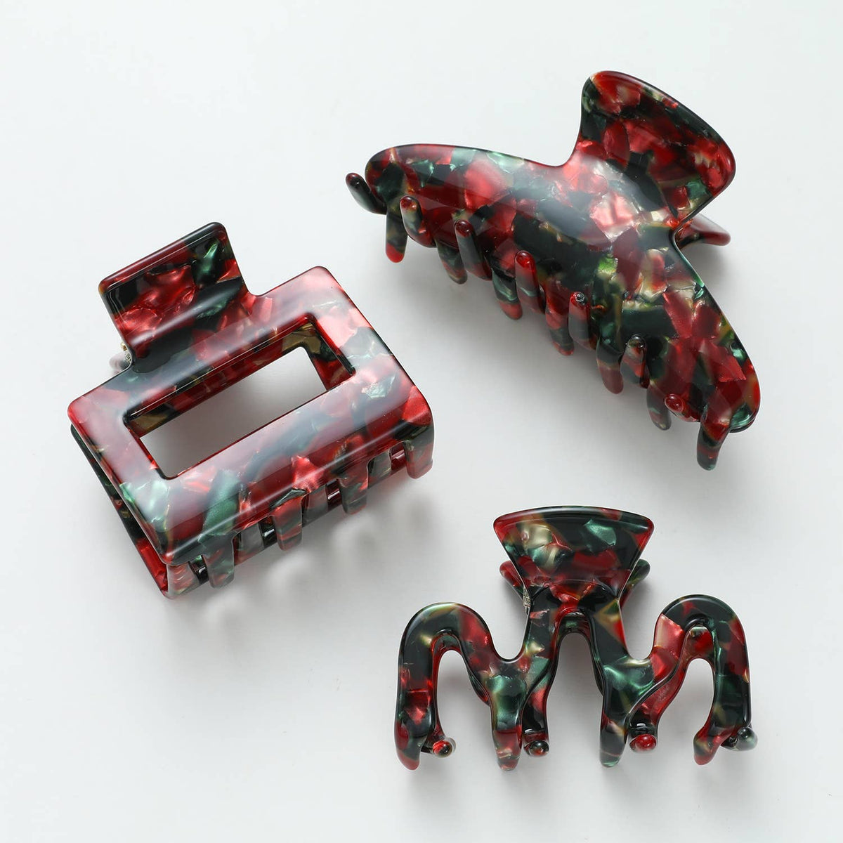 Three Vintage Christmas claw clip shapes together, rectangle, curved and small octopus, in marbled red green and gold acetate